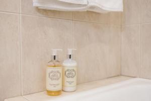 two bottles of alcohol are sitting on a bath tub at Casa da Calçada in Guimarães +46 photos