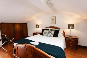 a bedroom with a large bed and two lamps at Casa da Calçada in Guimarães