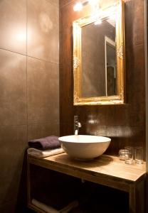 ein Badezimmer mit einem weißen Waschbecken und einem Spiegel in der Unterkunft Puurderij B&B en meer... in Nijeveen