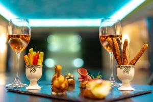 een tafel met drie glazen wijn en wat eten bij Swiss Diamond Hotel Prishtina in Pristina