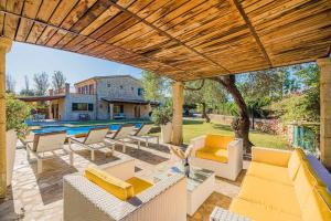 a patio with couches and chairs and a pool at Villa Font Xica Petit by Sealand Villas in El Port