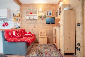 salon z czerwoną kanapą i lodówką w obiekcie Casa Fiore CIPAT 22038 w mieście Canale San Bovo
