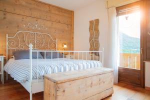 a bedroom with a white bed and a wooden wall at Casa Fiore CIPAT 22038 in Canale San Bovo