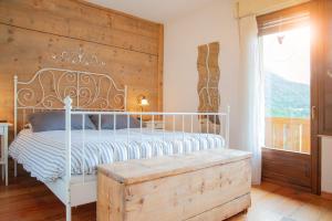 sypialnia z białym łóżkiem i drewnianą ścianą w obiekcie Casa Fiore CIPAT 22038 w mieście Canale San Bovo