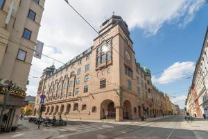 un grande edificio in mattoni con una torre dell'orologio su una strada di Nordic Host Luxury Apts - Prinsens Gate - Large Mezzanine Studio a Oslo