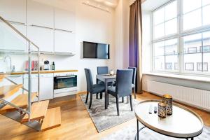 奧斯陸的住宿－Nordic Host Luxury Apts - Prinsens Gate - Large Mezzanine Studio，厨房以及带桌椅的起居室。