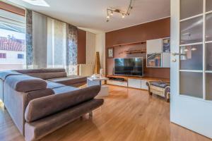 ein Wohnzimmer mit Couch und Fernseher in der Unterkunft Apartments Alin in Dramalj