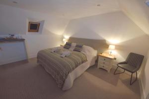 a small bedroom with a bed and a chair at Albatross B&B Dornoch in Dornoch