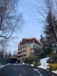 a large building with snow in front of it at Classic Residence in Poiana Brasov