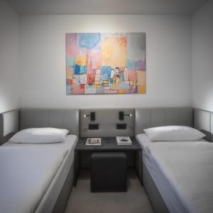 プルハイムにあるHome & Workのベッドが2つあり、壁に絵が飾られている部屋