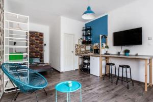 - un salon avec une table, des chaises et une télévision dans l'établissement BpR Colorist Apartments, à Budapest