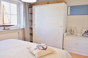 a bedroom with a bed and a window and a closet at Kapitaenshaus 10 in Laboe