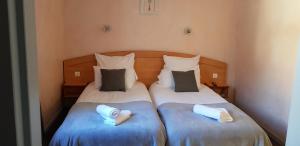 two beds in a small room with towels on them at Hôtel Terminus in Luz-Saint-Sauveur