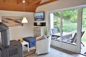 a living room with a sliding glass door leading to a patio at PW Strandmuschel in Laboe