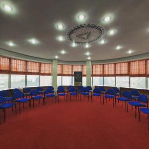 a large room with blue chairs and a podium at Hotel Kocibelli POOL & SPA in Korçë