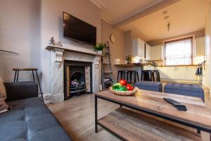 a living room with a table with a bowl of fruit on it at Large House - Contractors & Families & Private Parking in Northampton
