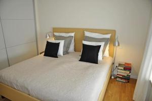 a bedroom with a bed with black and white pillows at Villa Bellevue I in Heikendorf