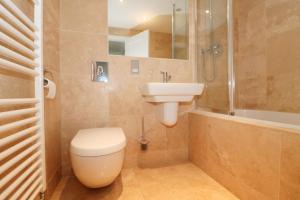 a bathroom with a toilet and a sink and a shower at BEACHSIDE SPACIOUS apartment, private garden in Saint Merryn