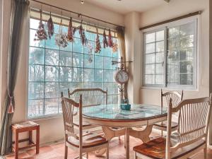 a dining room with a table and chairs and windows at Euro Country Villa in Ren'ai