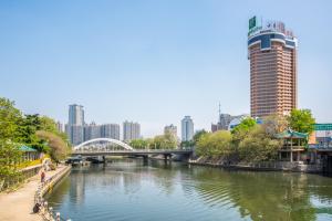 a river in a city with a bridge and buildings at Holiday Inn Hefei by IHG in Hefei
