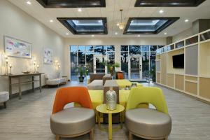 una sala de espera con mesas y sillas coloridas en Holiday Inn Hattiesburg - North, an IHG Hotel en Hattiesburg