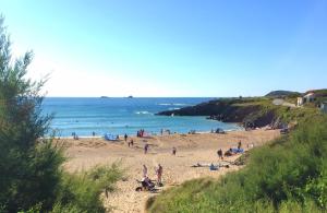 a group of people on a beach near the ocean at BEACHSIDE SPACIOUS apartment, private garden in Saint Merryn
