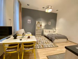 Cette petite chambre comprend un lit, une table et des chaises. dans l'établissement GRACIA APARTMENT HOUSE, à Budapest