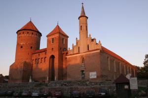 Kościół z dwoma wieżami i samochodami zaparkowanymi przed nim w obiekcie Zamek Reszel w mieście Reszel