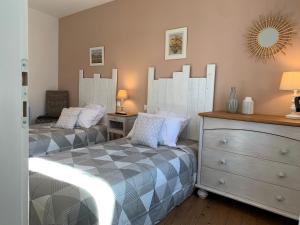 1 dormitorio con 2 camas, tocador y espejo en Solimany, en Saint-Gilles