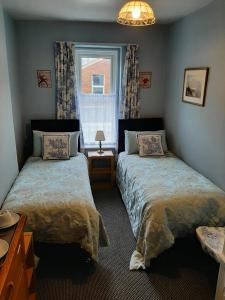 a bedroom with two beds and a window at Rosemead Guest House in Paignton