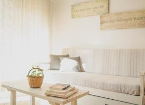 een woonkamer met een bank en een tafel met boeken bij Sa Barda - Formentera Break in Sant Ferran de Ses Roques