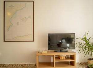 a flat screen tv sitting on top of a wooden table at Sa Barda - Formentera Break in Sant Ferran de Ses Roques