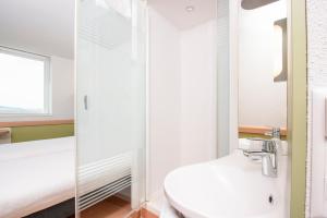 a bathroom with a sink, toilet and bathtub at ibis budget Bern Expo in Bern