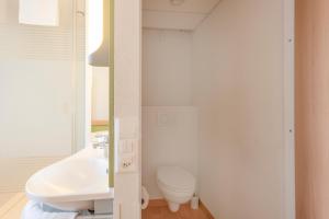a white toilet sitting in a bathroom next to a sink at ibis budget Bern Expo in Bern