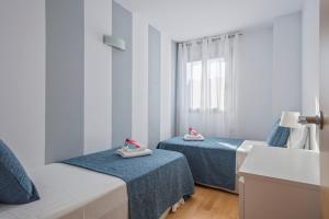 a room with two beds with shoes on them at Alcam Rubi in Rubí