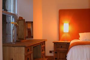 a bedroom with a bed and a dresser with a lamp at Kingsview Apartment in Stirling
