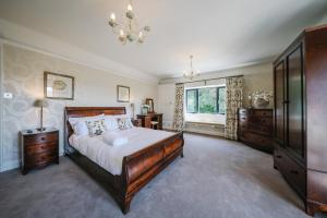 a bedroom with a large bed and a chandelier at Cherry Trees in Windermere