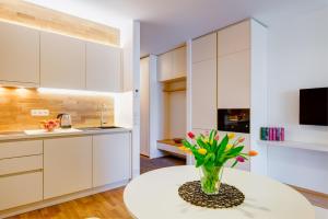 a kitchen with white cabinets and a vase of flowers on a table at Apartman Medvědín 306 in Špindlerův Mlýn