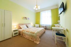 a bedroom with a bed and a desk and a television at Hotel Pension Dahlem in Berlin +24 photos