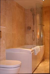 ein Bad mit einer Badewanne, einem WC und einer Dusche in der Unterkunft Kingsview Apartment in Stirling