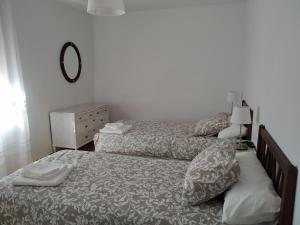 1 dormitorio con 2 camas y espejo en Apartamento Cervantes, en Teruel
