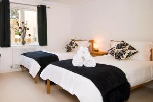 een slaapkamer met twee bedden met witte schoenen erop bij BY THE BEACH, spacious apartment in Saint Merryn