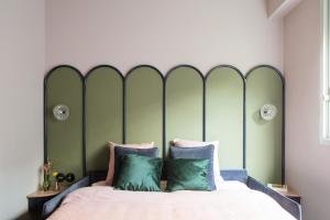 - un lit avec une tête de lit verte dans une chambre dans l'établissement Joie Paris GARE MONTPARNASSE, à Paris