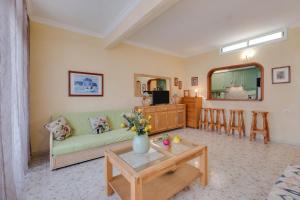 a living room with a green couch and a table at Bungalow Los Gigantes in Acantilado de los Gigantes