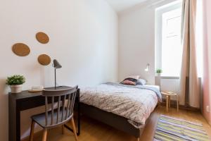 a bedroom with a bed and a desk and a window at Apartment Jeseniova in Prague