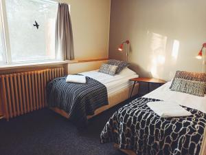 a hotel room with two beds and a window at Hotel Hjardarbol in Selfoss