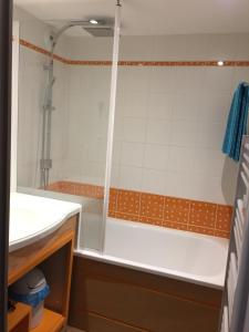 La salle de bains est pourvue d'une douche et d'une baignoire blanche. dans l'établissement Corniche de la Plage classé 3 étoiles, à Bénodet