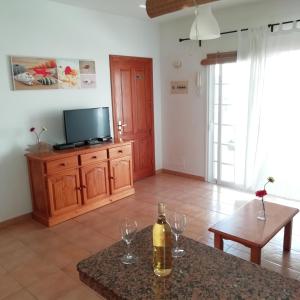 ein Wohnzimmer mit einer Flasche Wein auf dem Tisch in der Unterkunft Rincón del descanso in Orzola