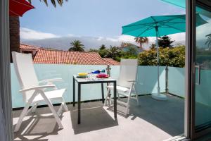 a patio with a table and two chairs and an umbrella at CasaColores Apartamentos in Puerto de la Cruz