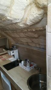 a kitchen with a sink and a stone wall at Il sottano borgo antico in Bari
